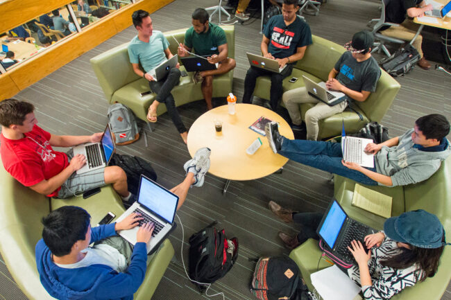 Students sitting in a circle around a table in the Kresge Engineering Library