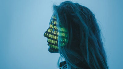 Image of woman with binary code superimposed on her face.