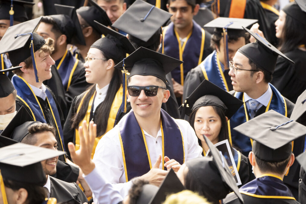 A shot of graduates donning their mortarboard caps at a commencement ceremony.
