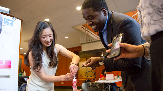 two students with a prototype at the capstone showcase