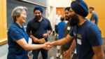 Dean Liu greets aerospace engineering student Nihal Gulati and his family in a classroom at Homecoming